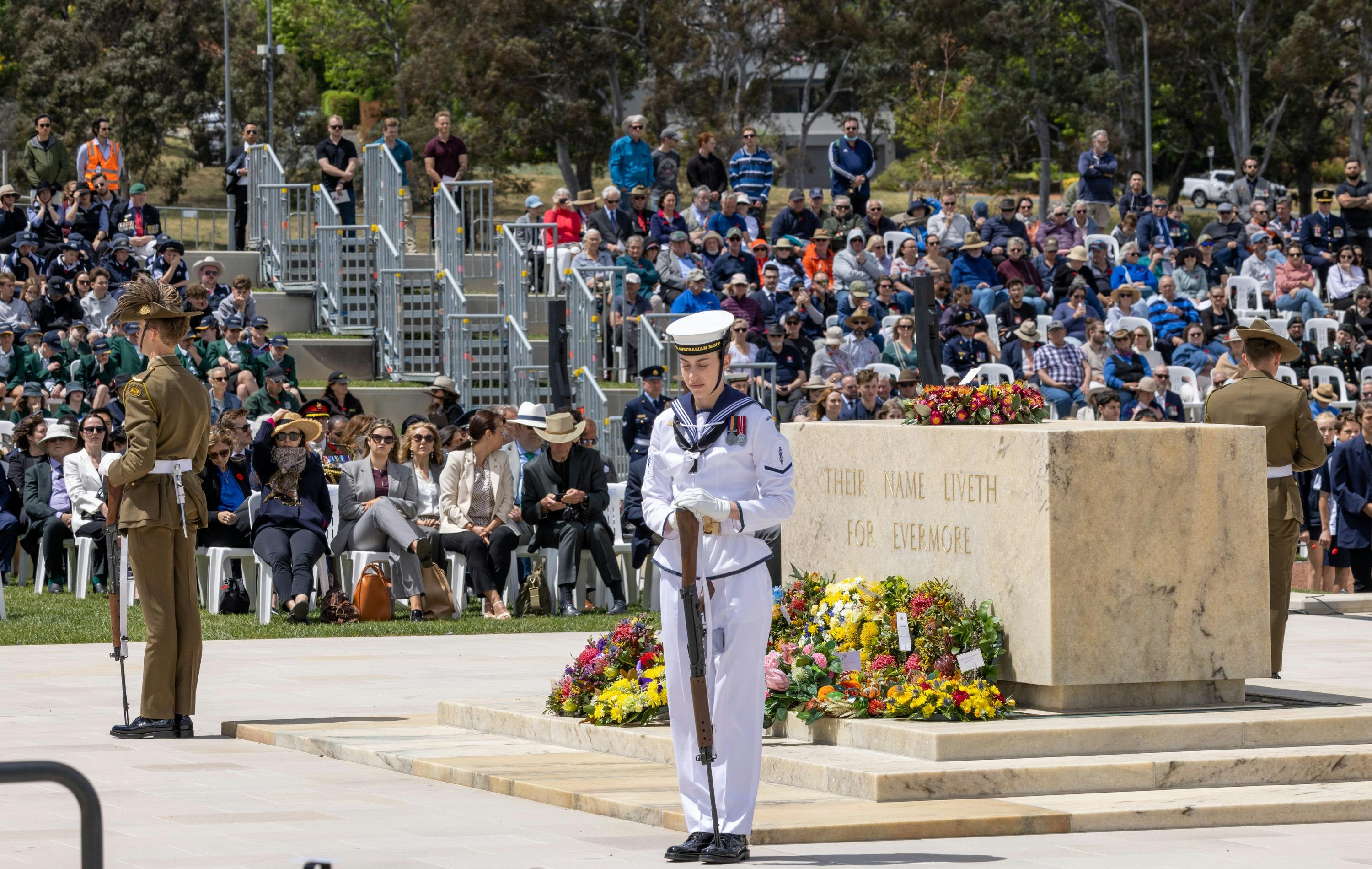 servicepersons standing at each corner of the stone of remembrance