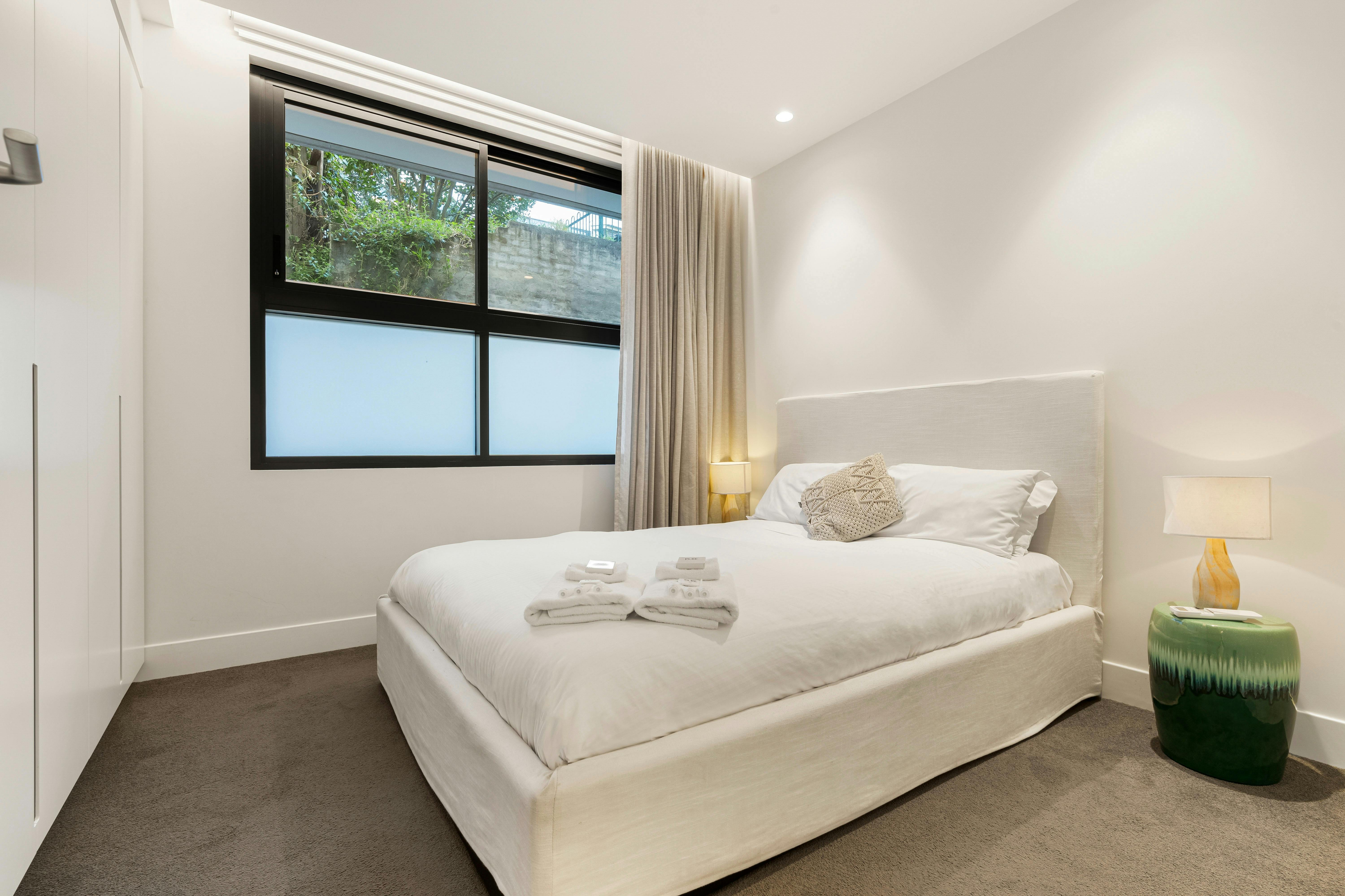 Cozy bedroom with soft lighting and a stylish green lamp.
