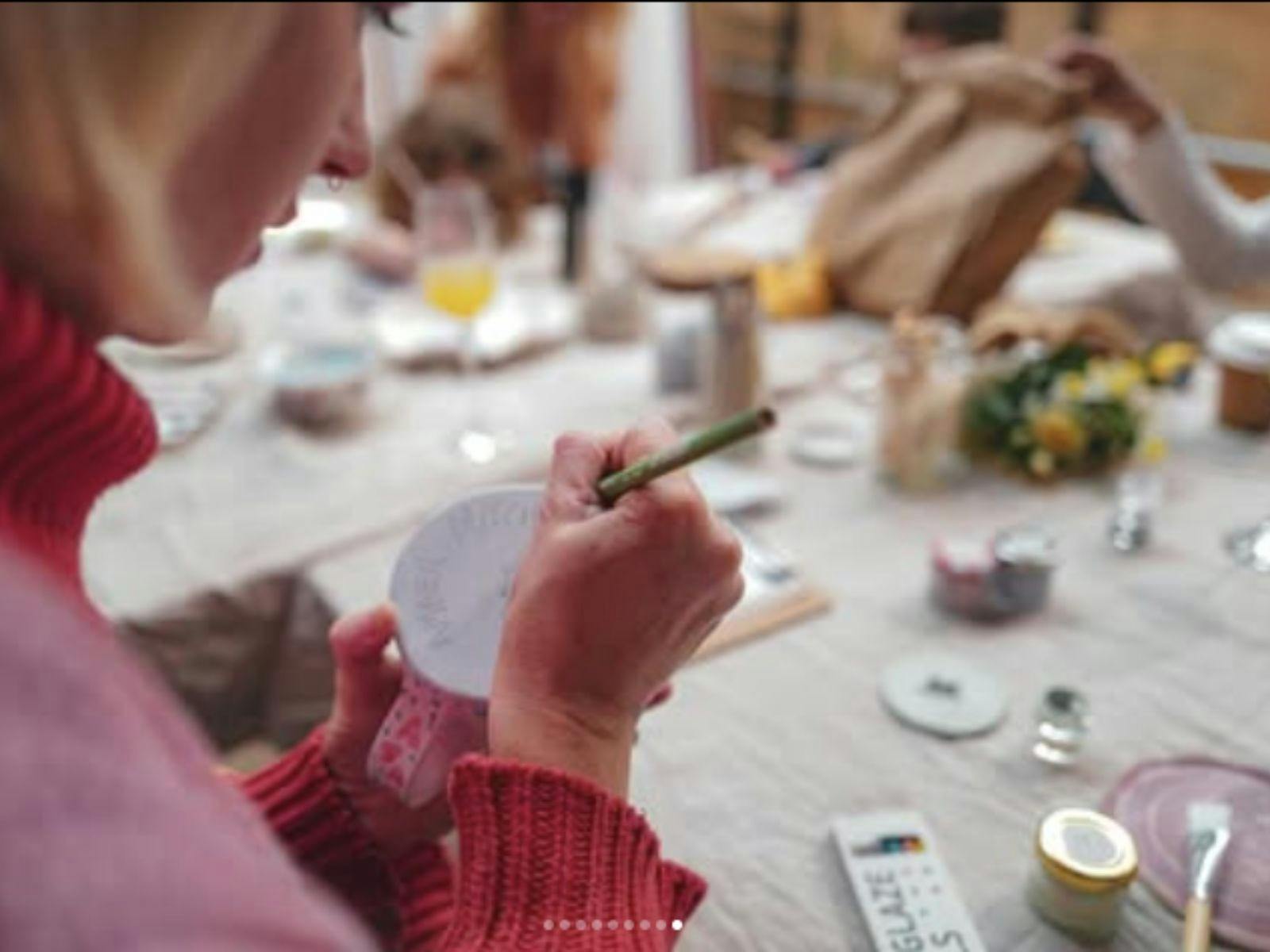 Person painting a cup