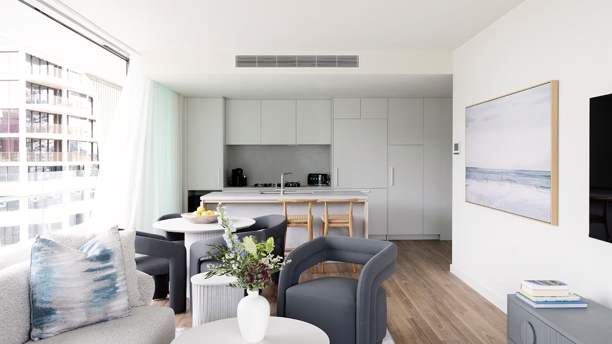 Open-plan living area at Kirra Point Holiday Apartments featuring coastal décor and full kitchen