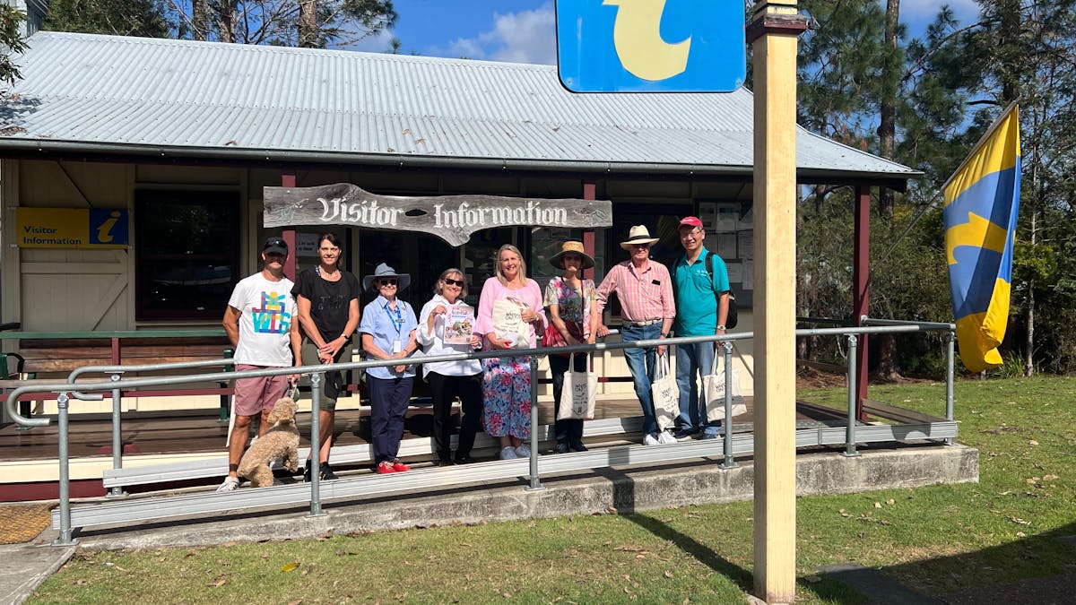 A guide with the walking group tour standing in front of the Samford Visitor Centre
