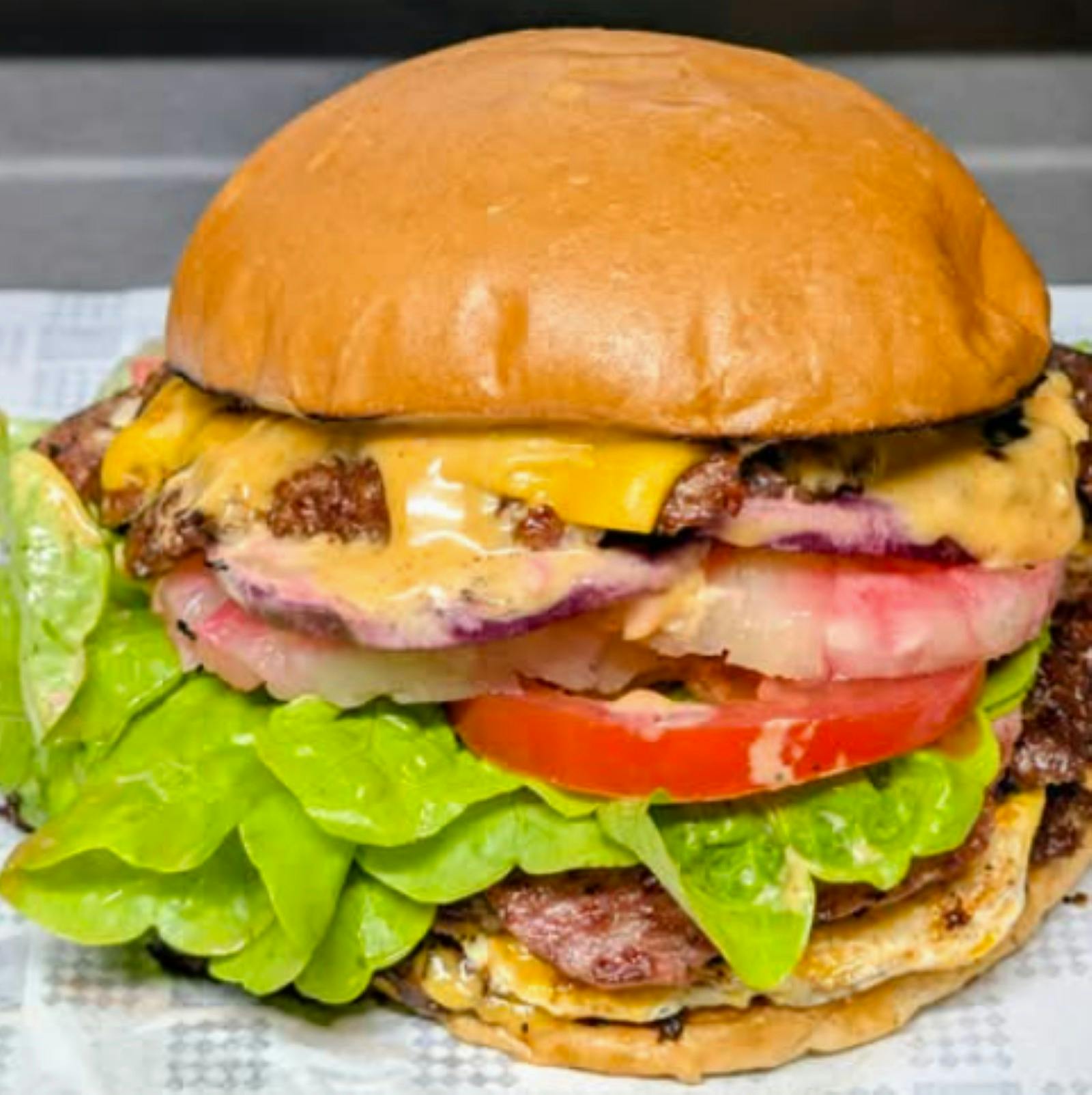 side view of a burger with lettuce meat cheese and tomato