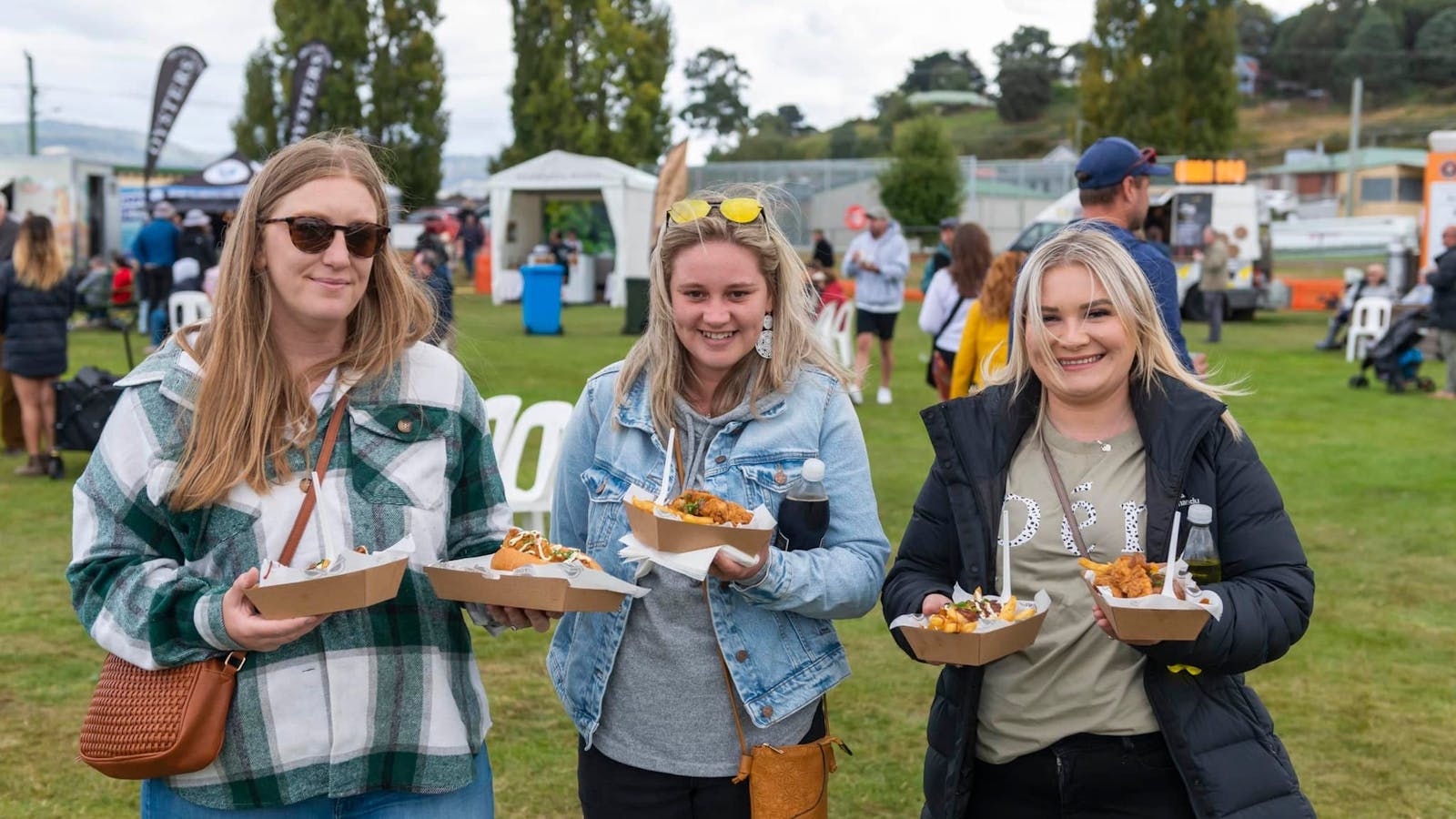 Three visitors showing their delicious meal.