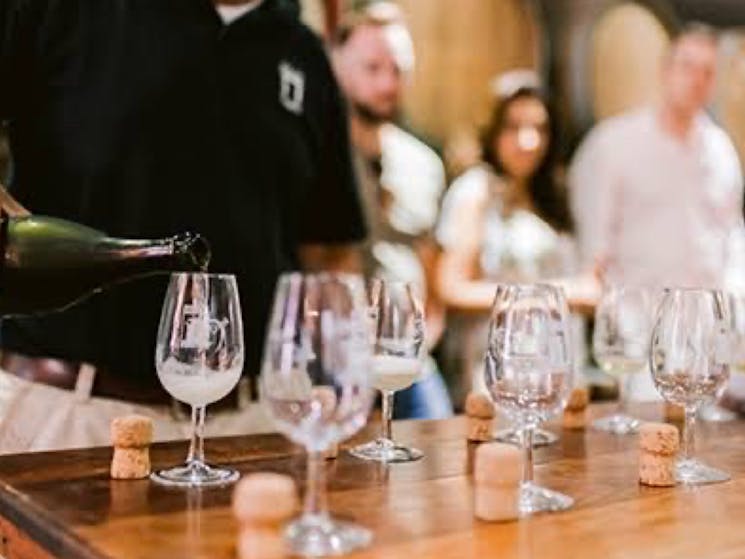 Photo of wine being poured into wine glasses for a wine tasting experience.