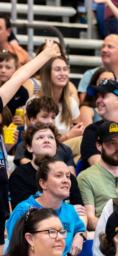 UC Capitals fan jumping and cheering in the crowd wearing Caps merch.