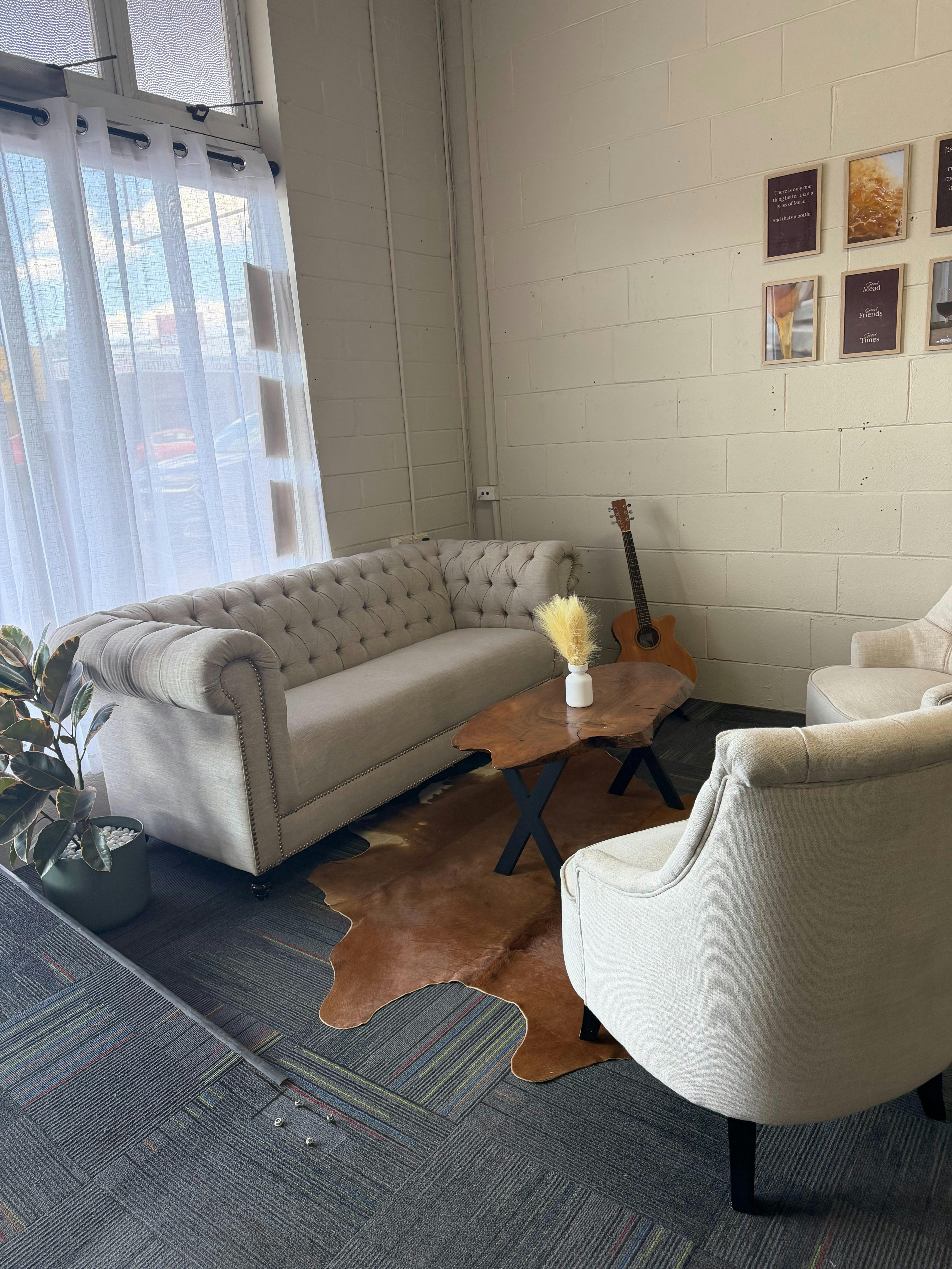 Lounge area for extra comfort in the tasting room. Cow hide rug, chesterfield couch and arm chairs.
