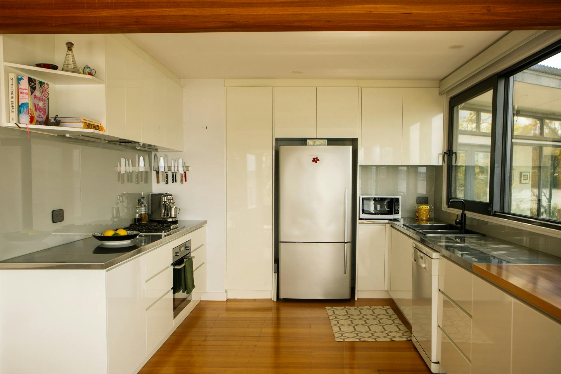 Fully equipped modern kitchen at Snug on the Bay with a gas cooktop, oven, dishwasher and  fridge