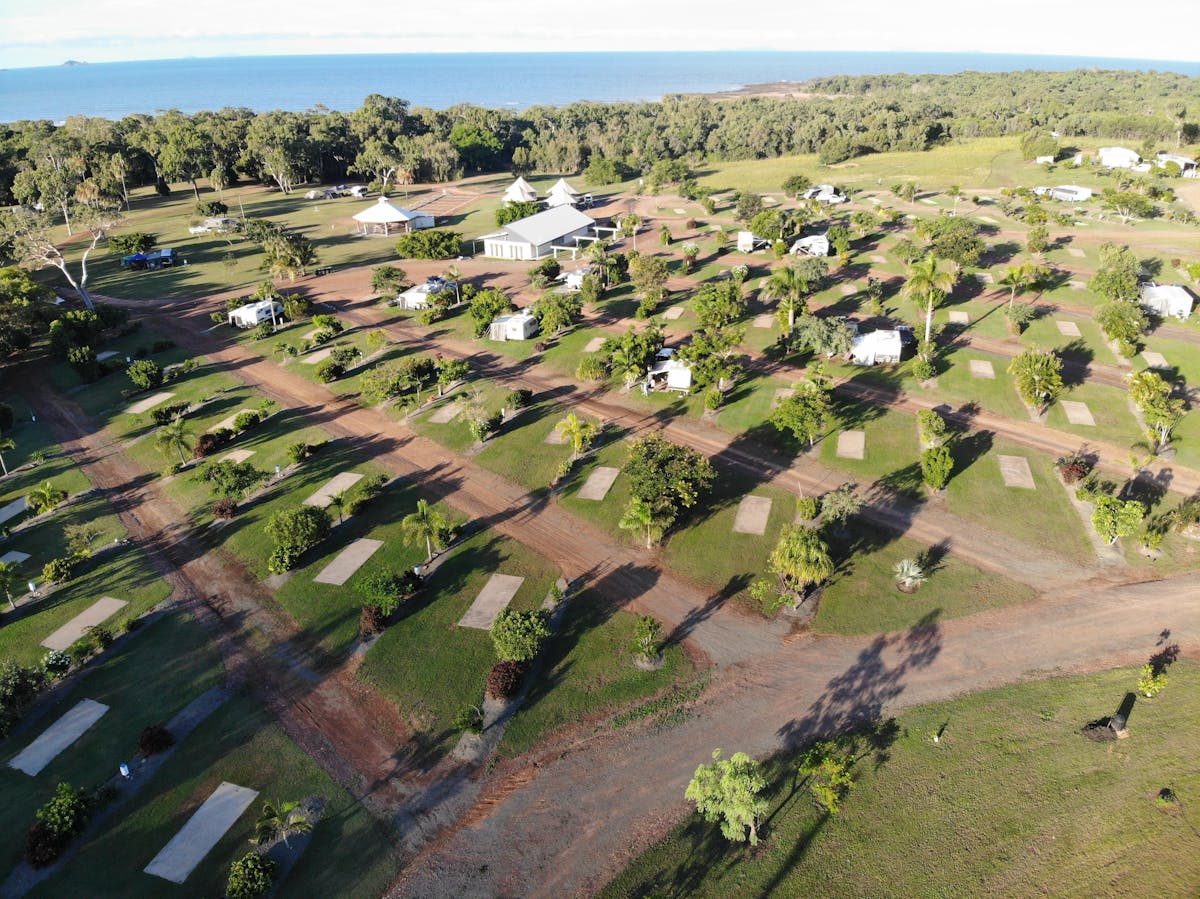 Well grassed and treed drive thru sites with ocean in background