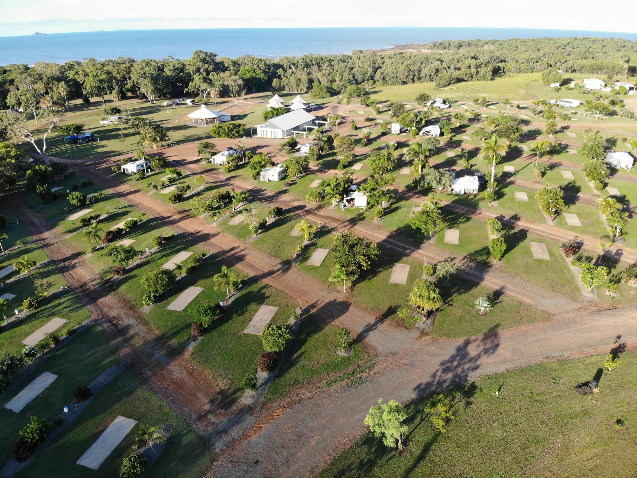 Well grassed and treed drive thru sites with ocean in background Well grassed and treed drive thru sites with ocean in background