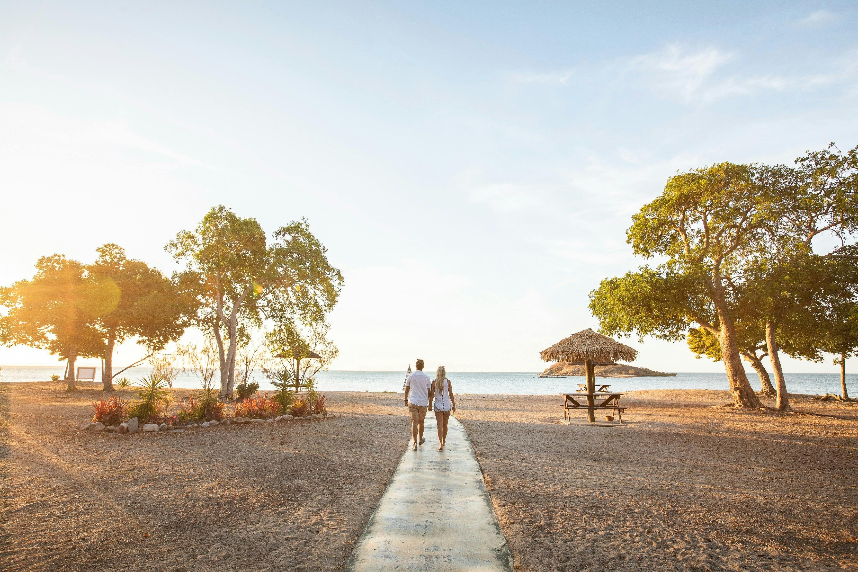Couple walking onto to sunset at a beach