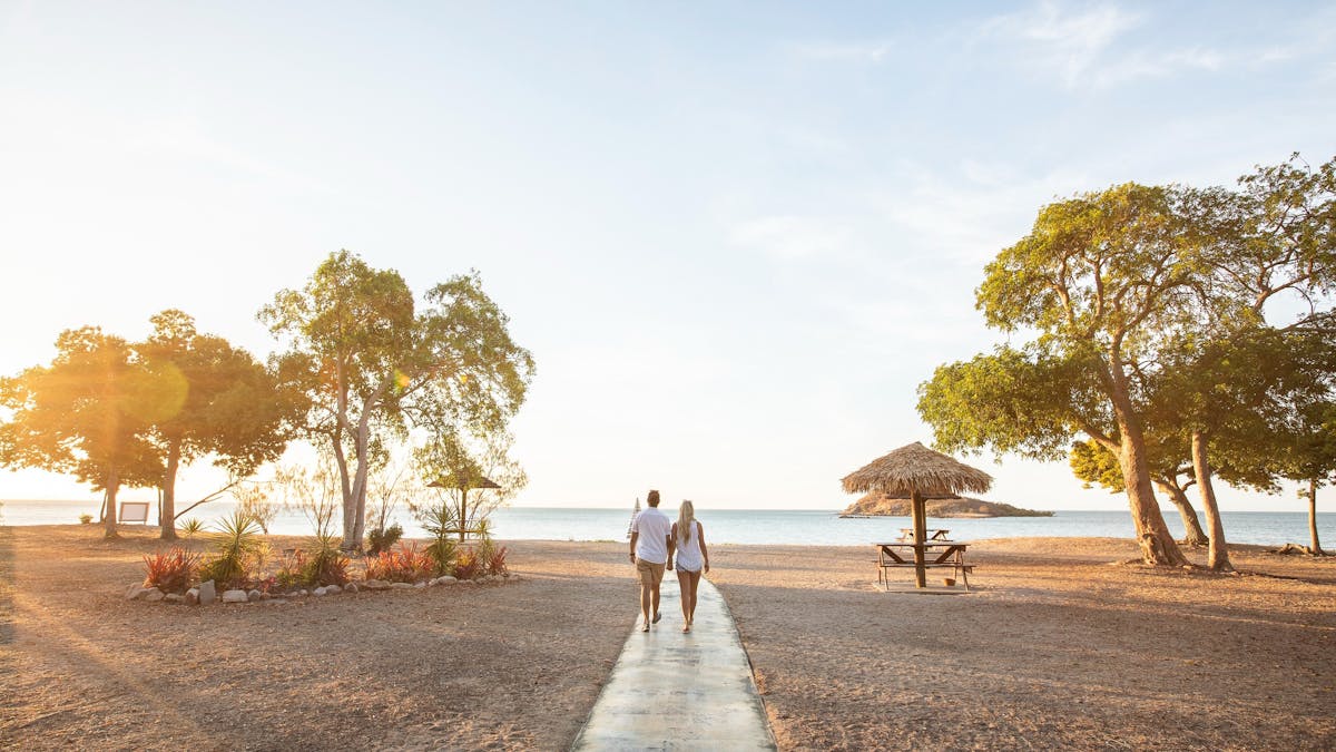 Couple walking onto to sunset at a beach
