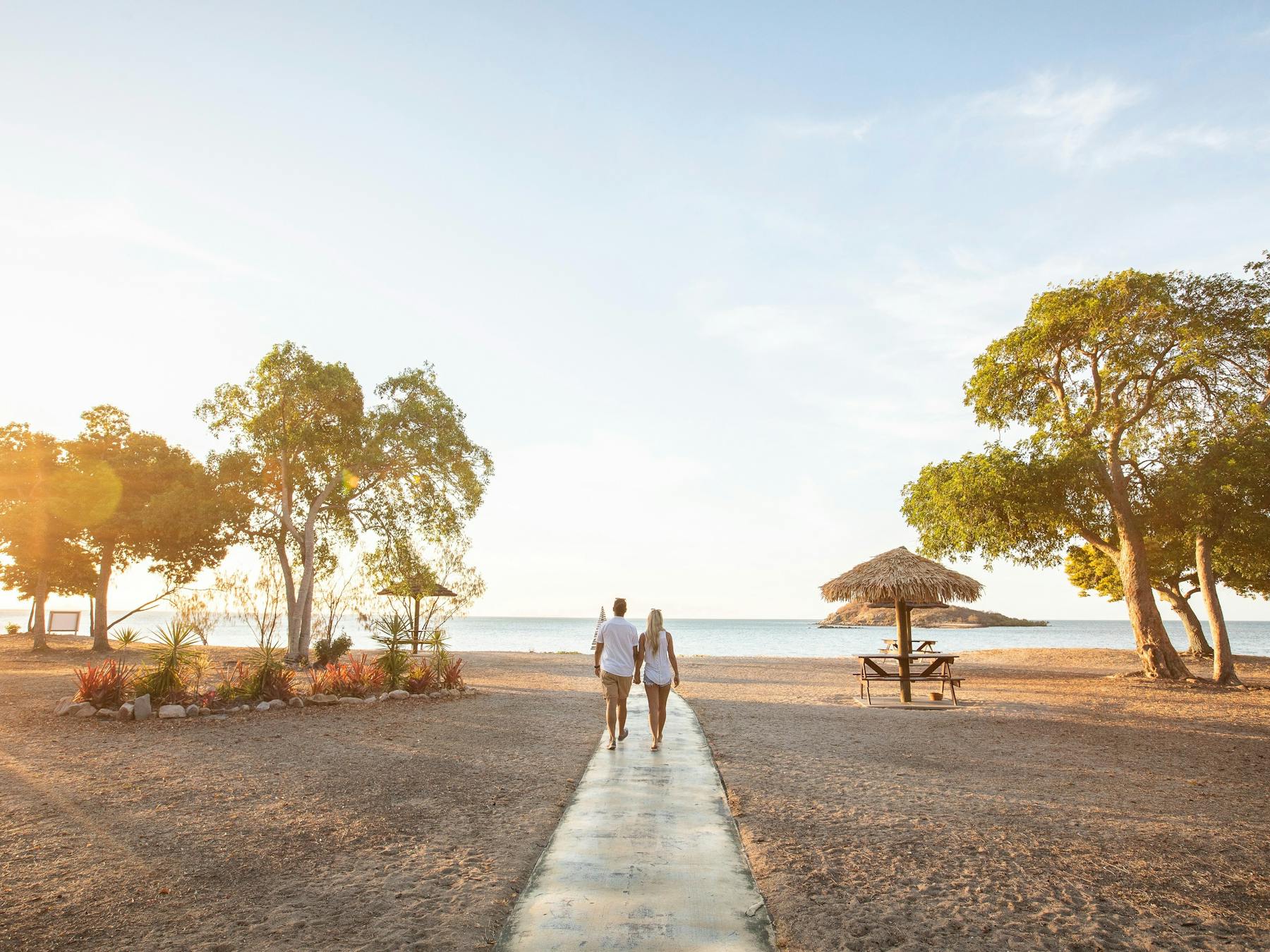 Couple walking onto to sunset at a beach