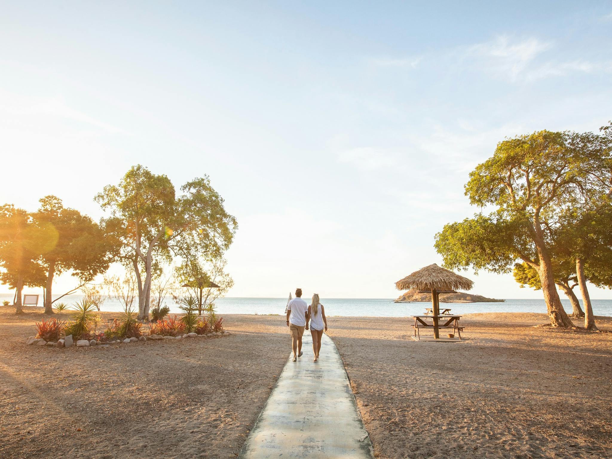 Couple walking onto to sunset at a beach