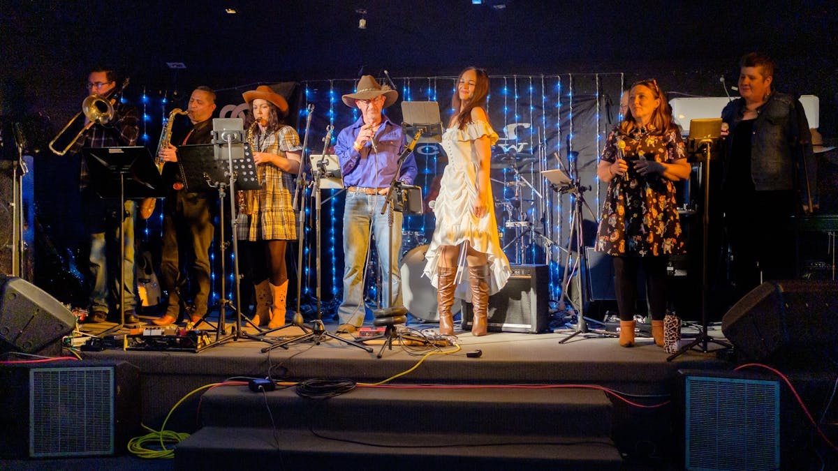 A band performing on stage with singers and instrumentalists