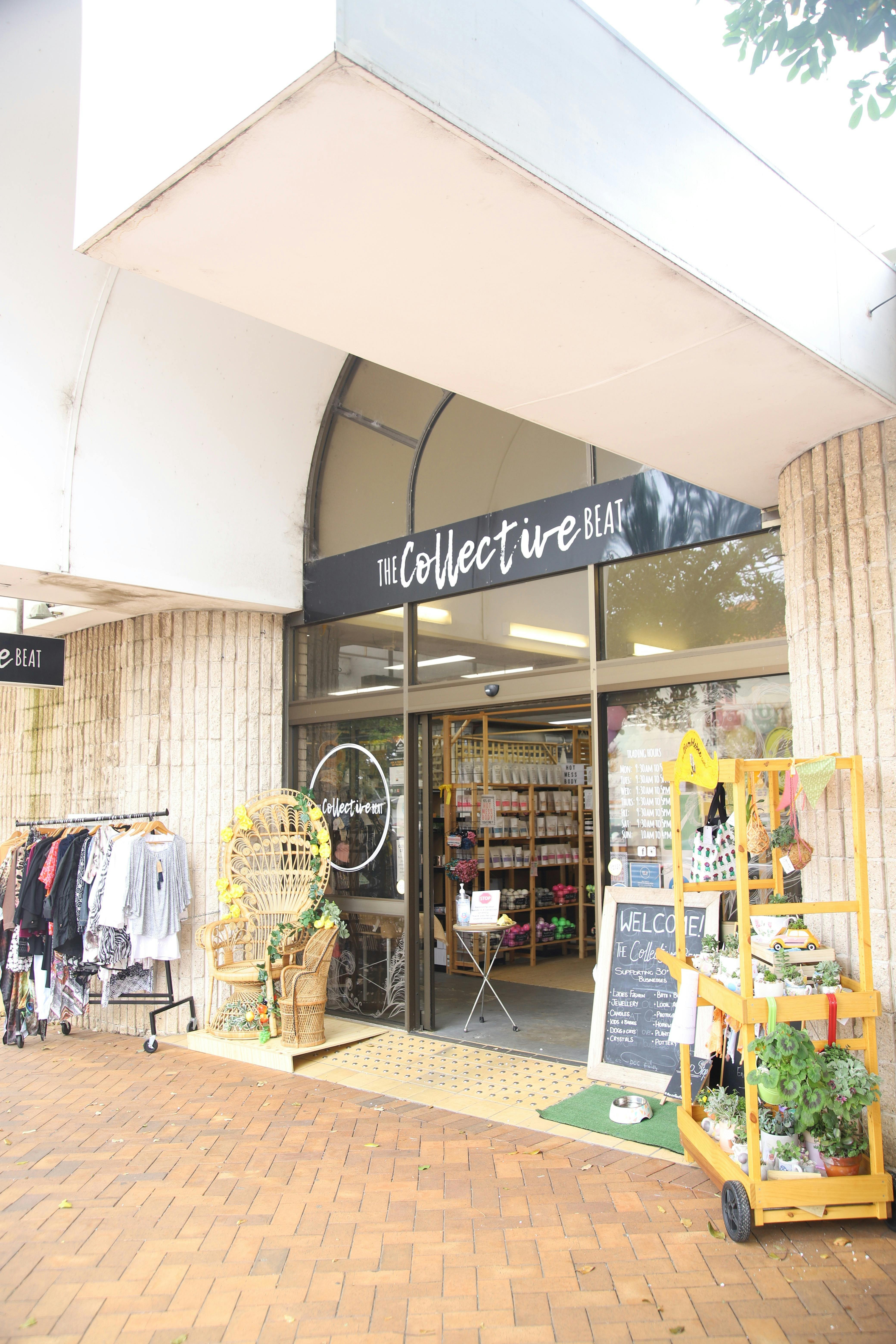 'The Collective Beat'라는 문구가 적힌 건물. 앞에는 옷걸이 등나무 의자 그리고 식물들이 놓여 있다.