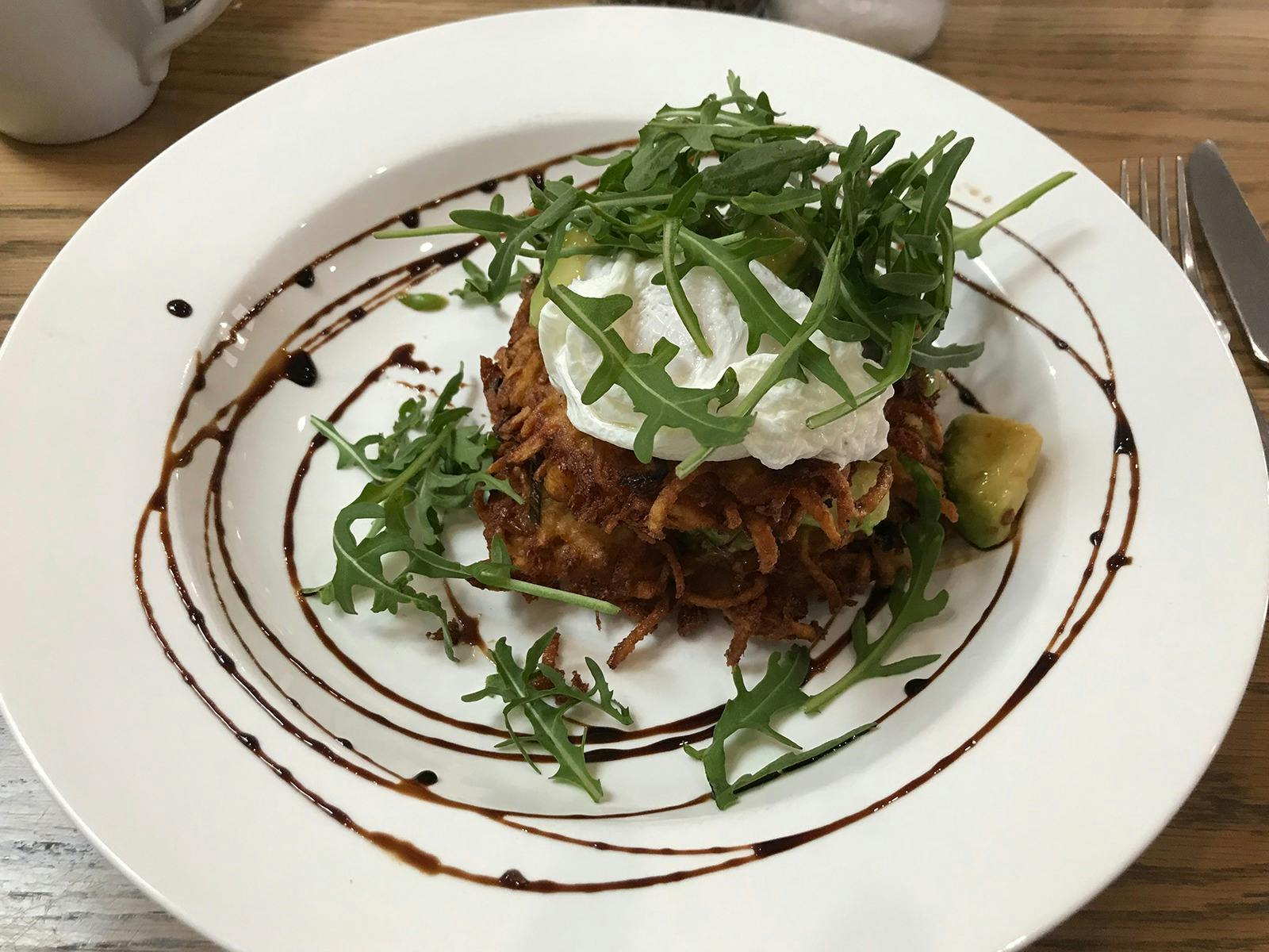 Corn and potato fritters served with sweet chilli and avocado, rocket and a poached egg
