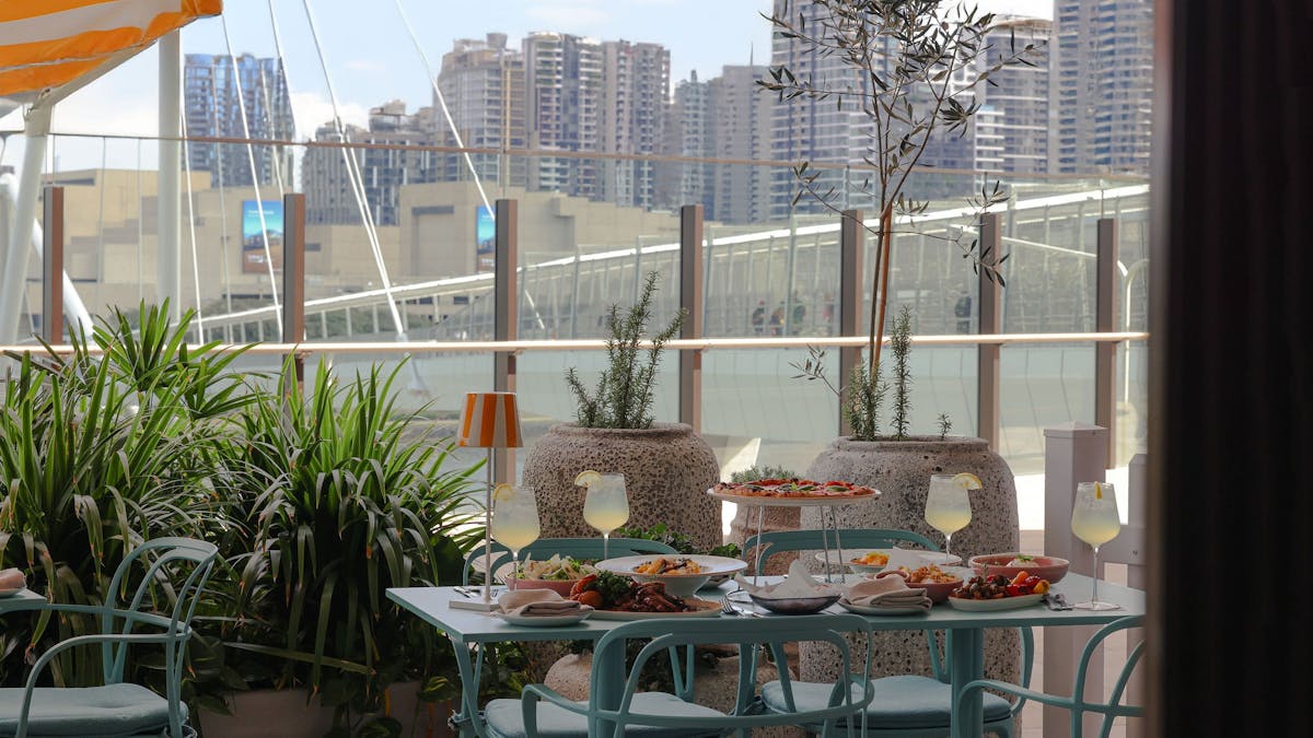 A table overlooking the river filled with Italian food