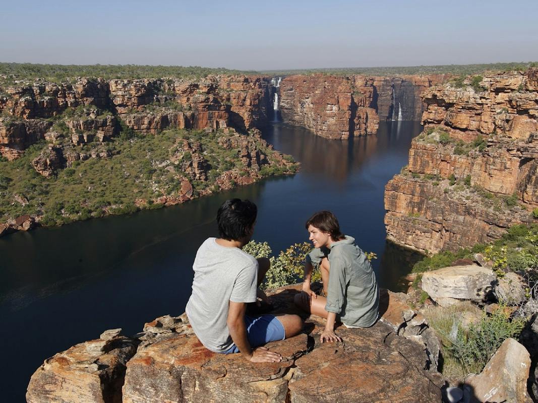 couple sitting on cliffs across the gorge from Oomari King George Falls