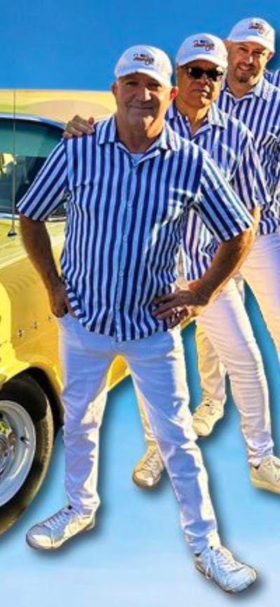 5 men dressed as the Beach Boys standing next to a yellow car