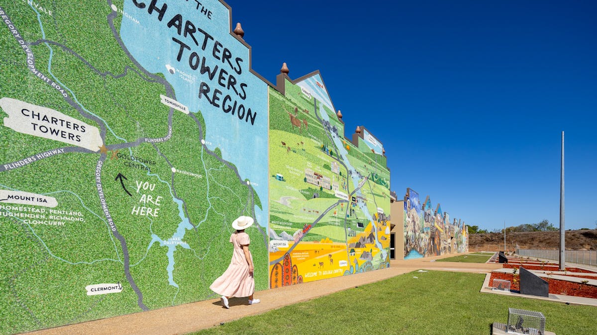 Lady walking in front of Charters Towers Wall of History 1872-1922