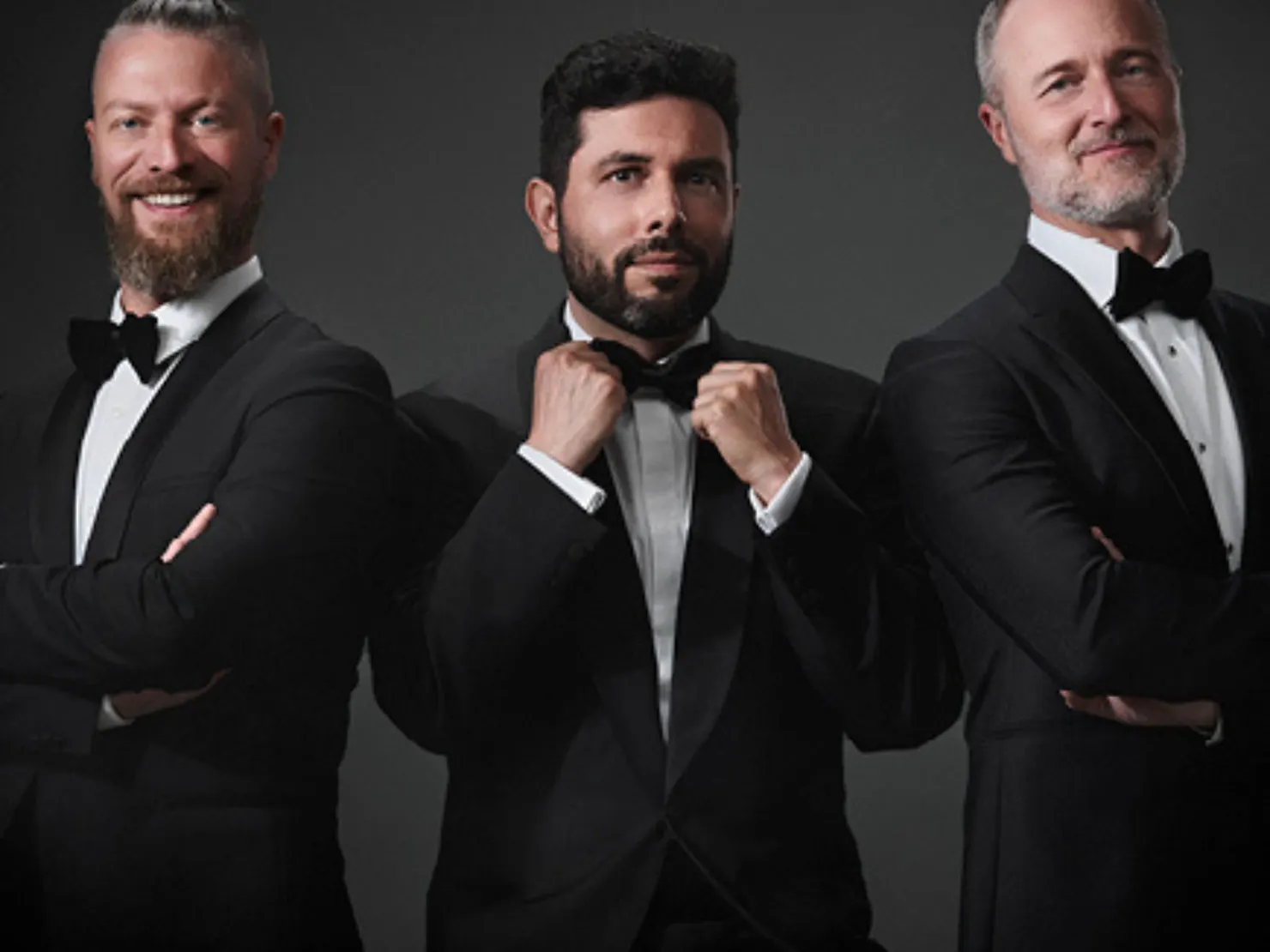3 men in black tux with white shirts and black bow ties