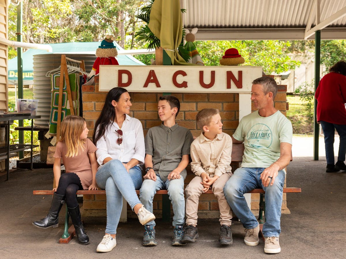 A family seating in front of the Dagun sign at the Dagun Station