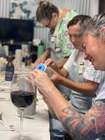 Kylie enjoying a glass of wine while creating a masterpiece in clay