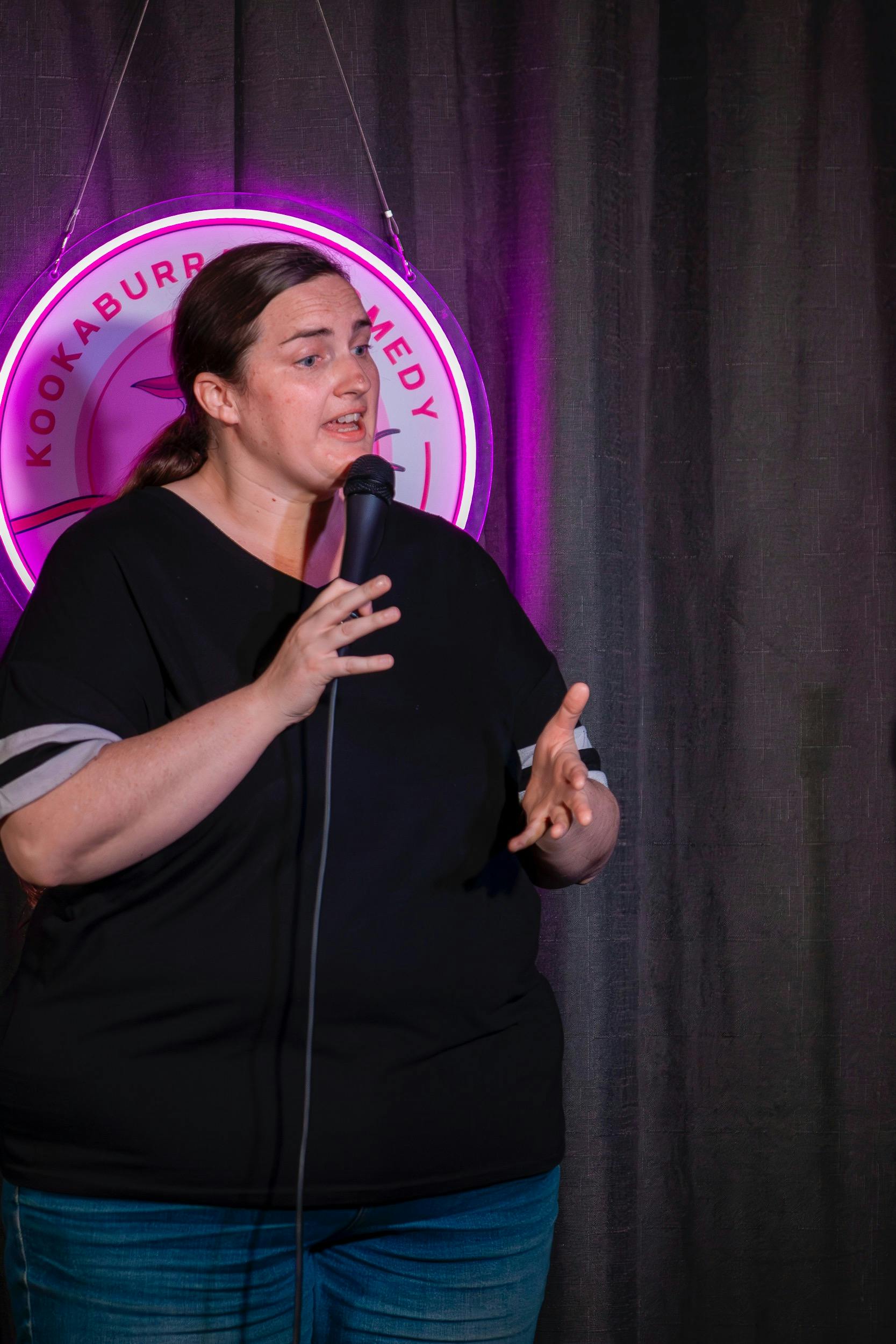 Eddy Rockefeller holds a microphone and gestures while talking.