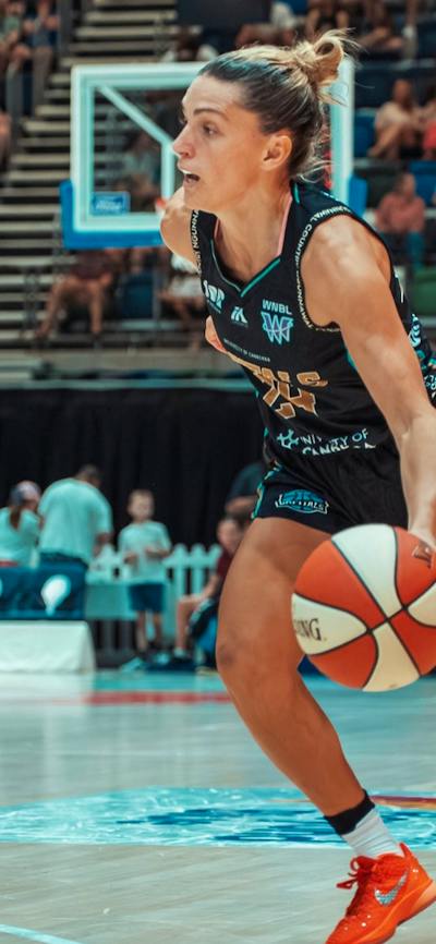 Basketball player dribbles the ball while running.