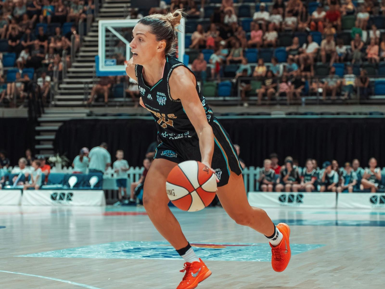 Basketball player dribbles the ball while running.