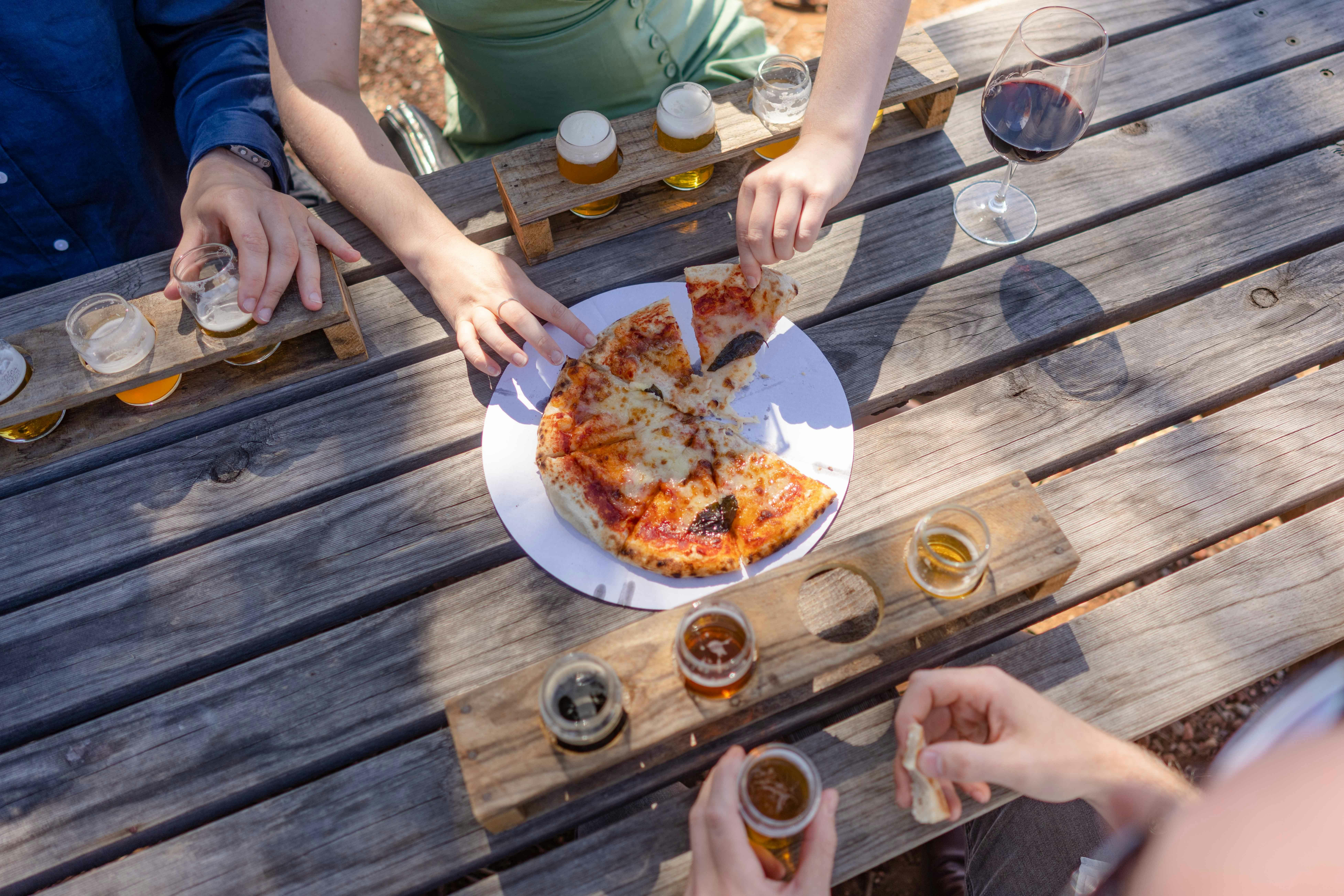 Rambling tour group enjoying stonebaked pizzas and craft beer while listening to live music