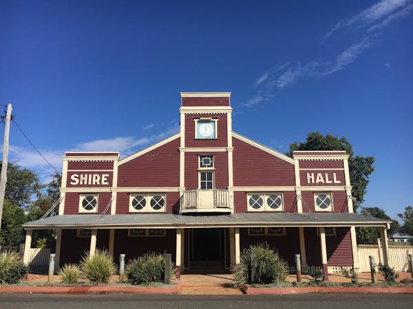 Front facade of the Surat Shire Hall, a dark red art-deco building with white trim