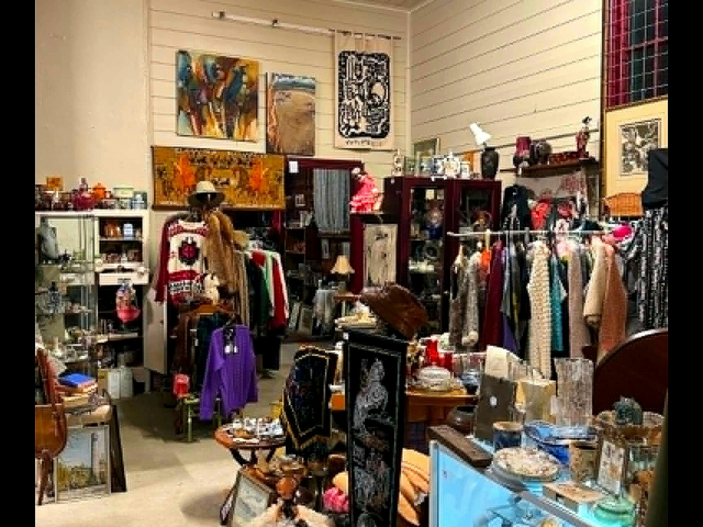Vintage clothing racks, hats, and textiles in antique shop