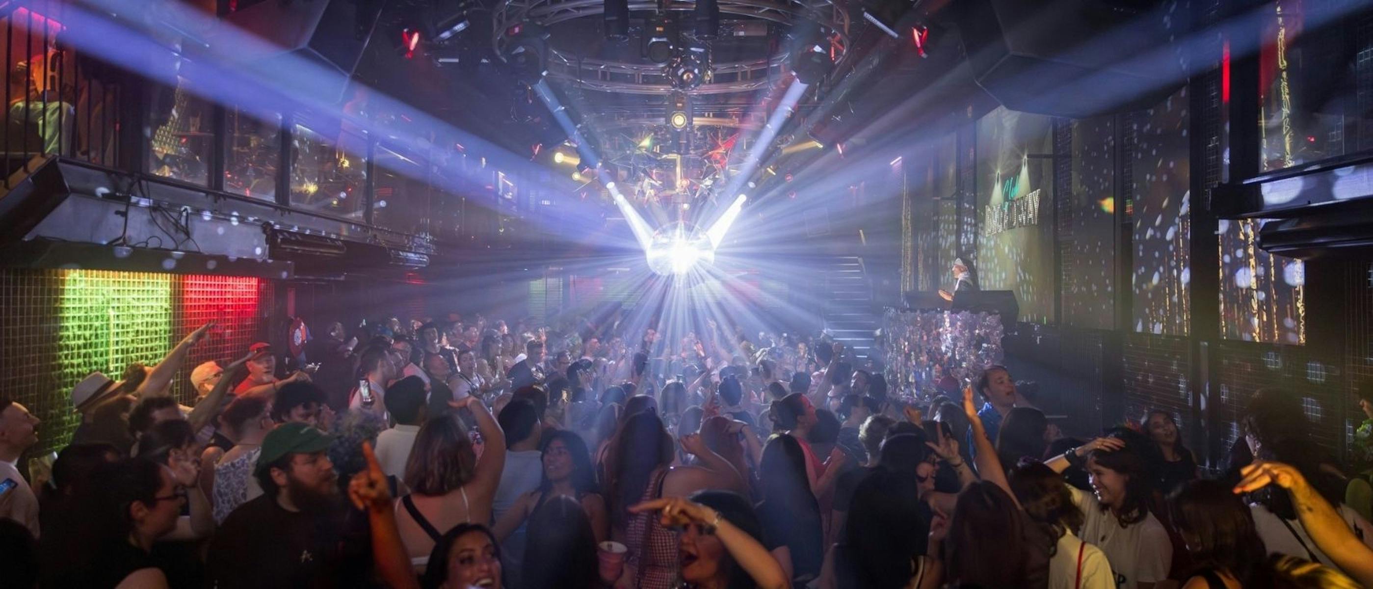 A large room full of people dancing under a disco ball