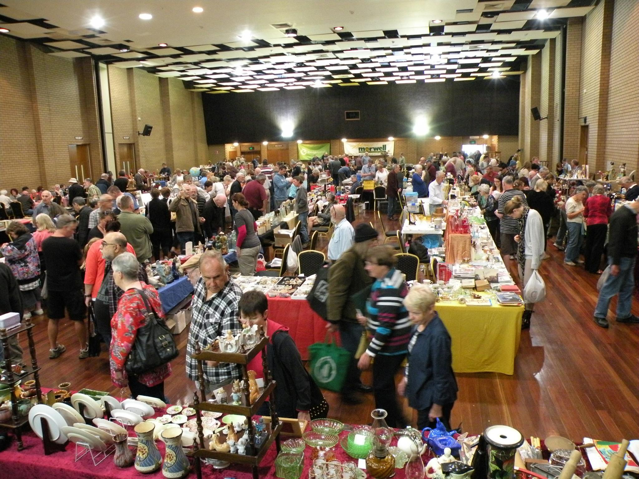 an indoor venue with people looking at a range of vintage items and homewares on tables