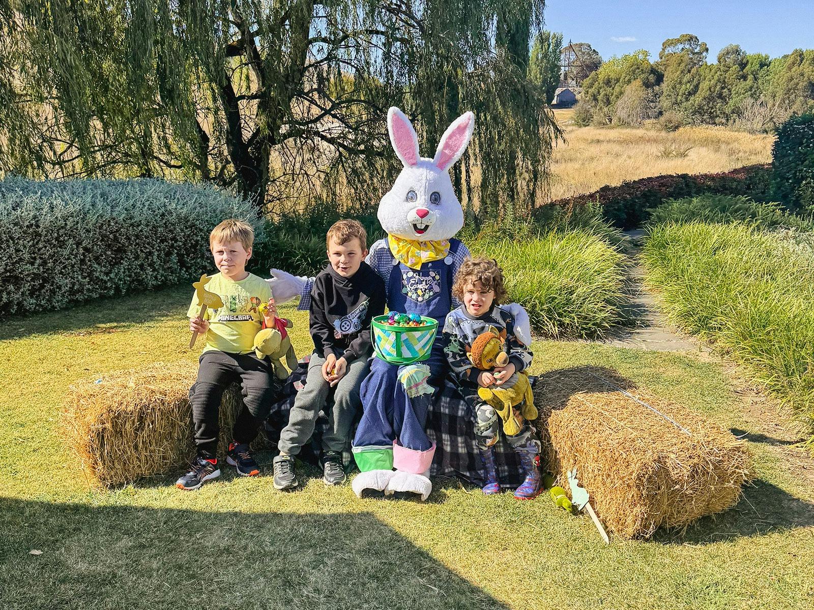Some children posting for a photo with someone dressed as the Easter Bunny