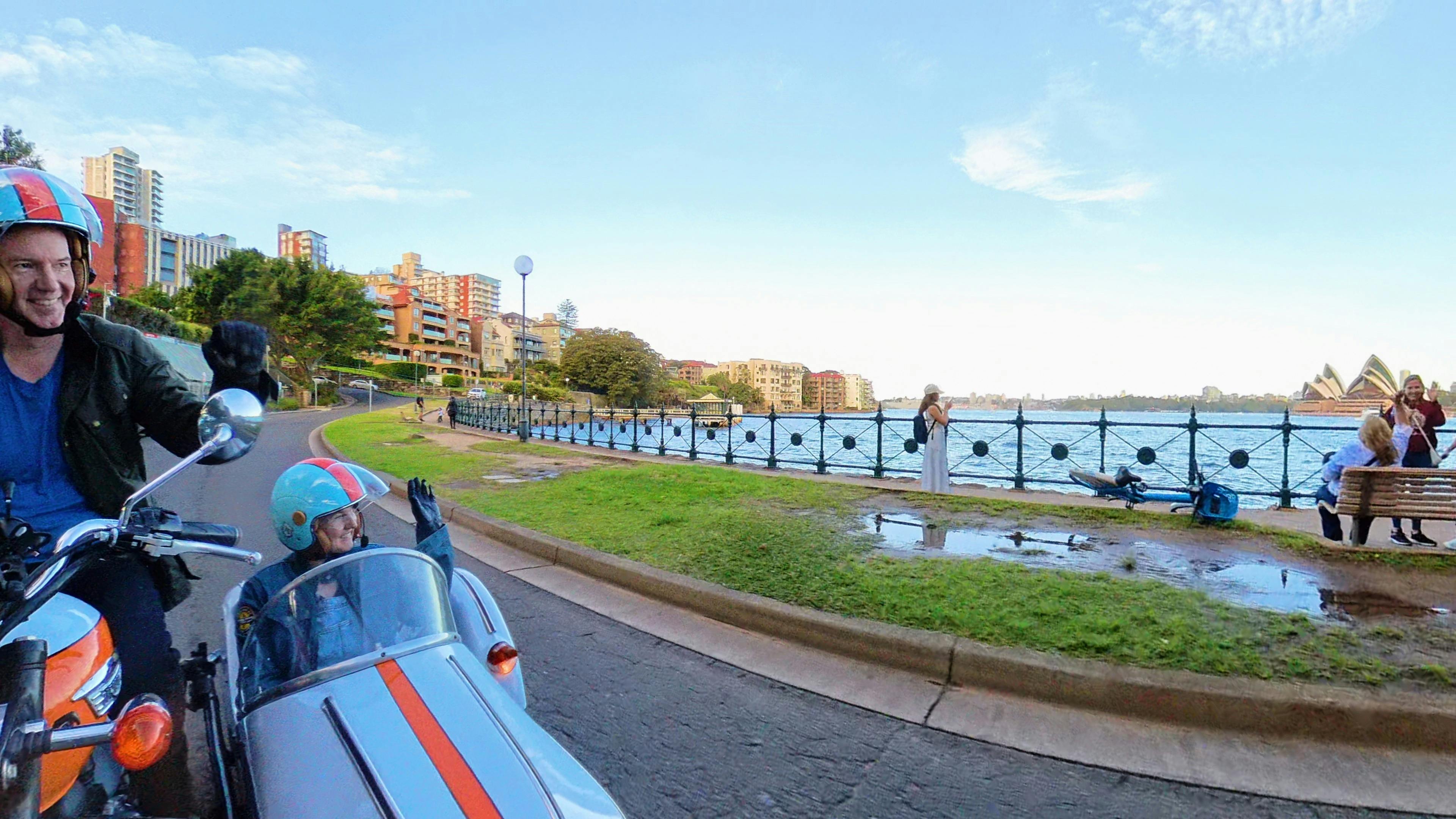 A woman waving from a sidecar opposite the  Sydney Opera House