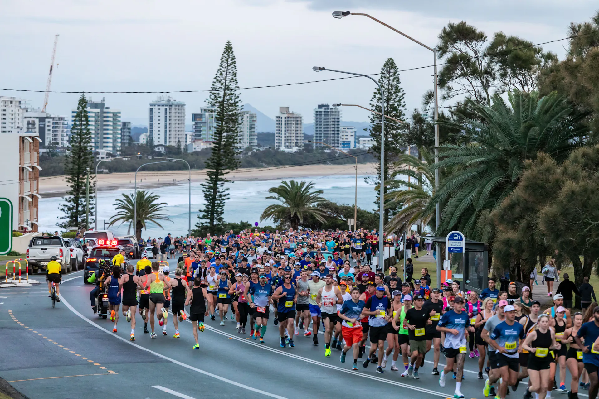 People running up hill with beach in background