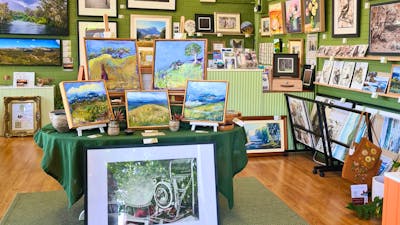 Artworks displayed on a central table and artworks hung on the walls