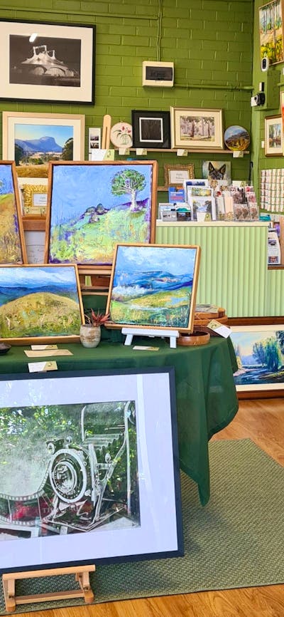 Artworks displayed on a central table and artworks hung on the walls