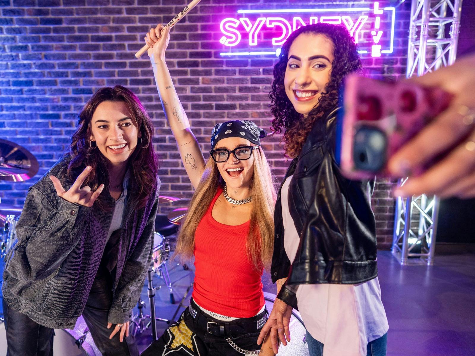 Guests taking a selfie with G Flip's wax figure