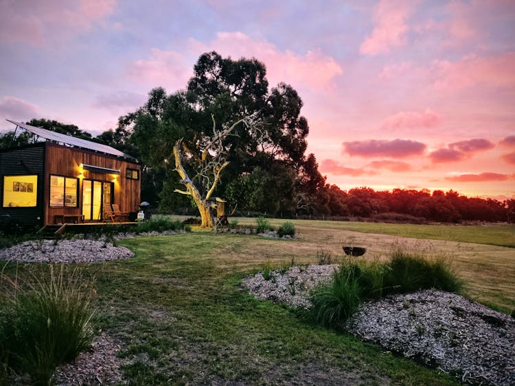 Hero shot of our retreat on dusk. Colourful sky in the background and a floodlight gumtree.