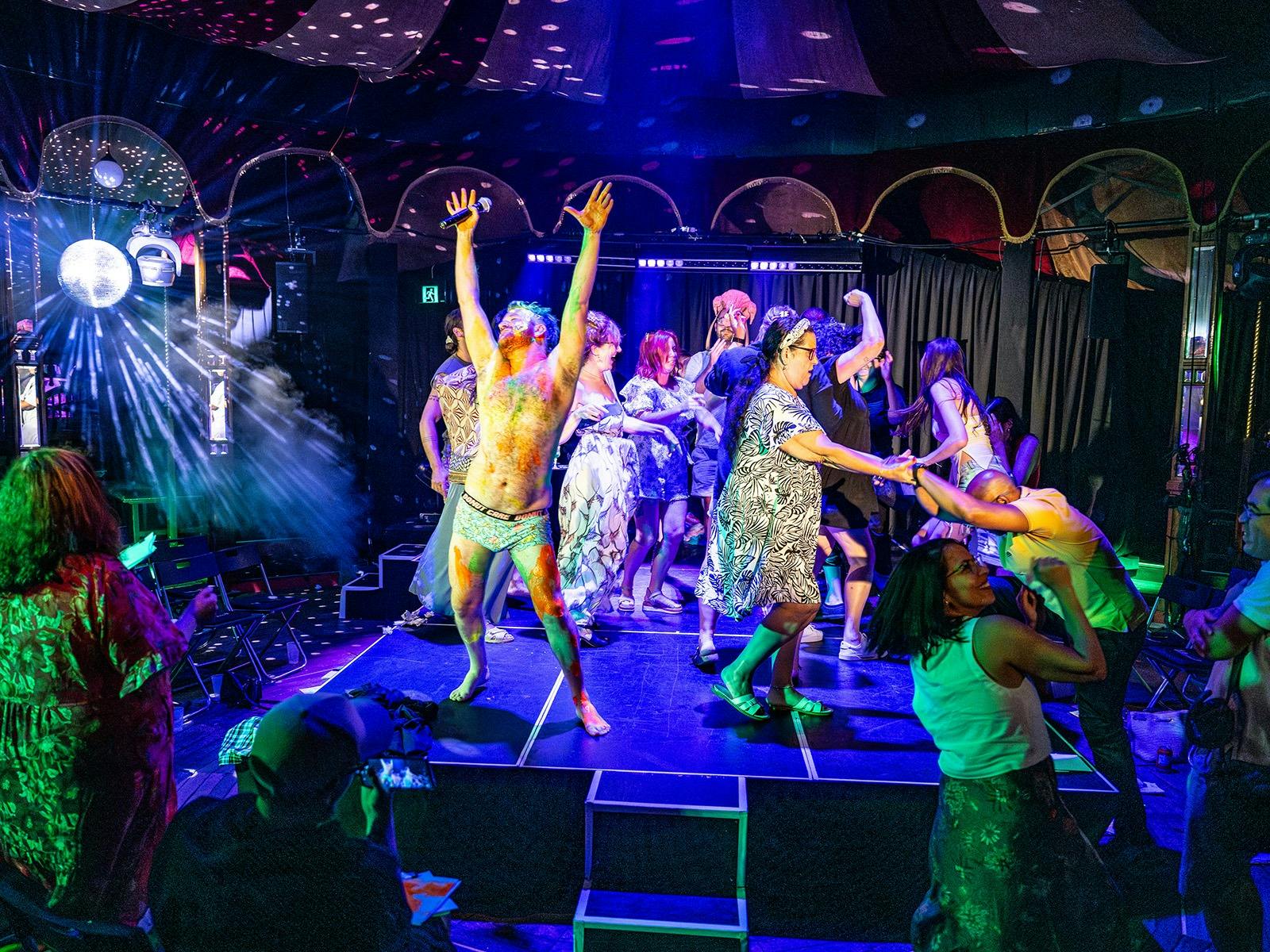 Audience dancing on stage under disco lights