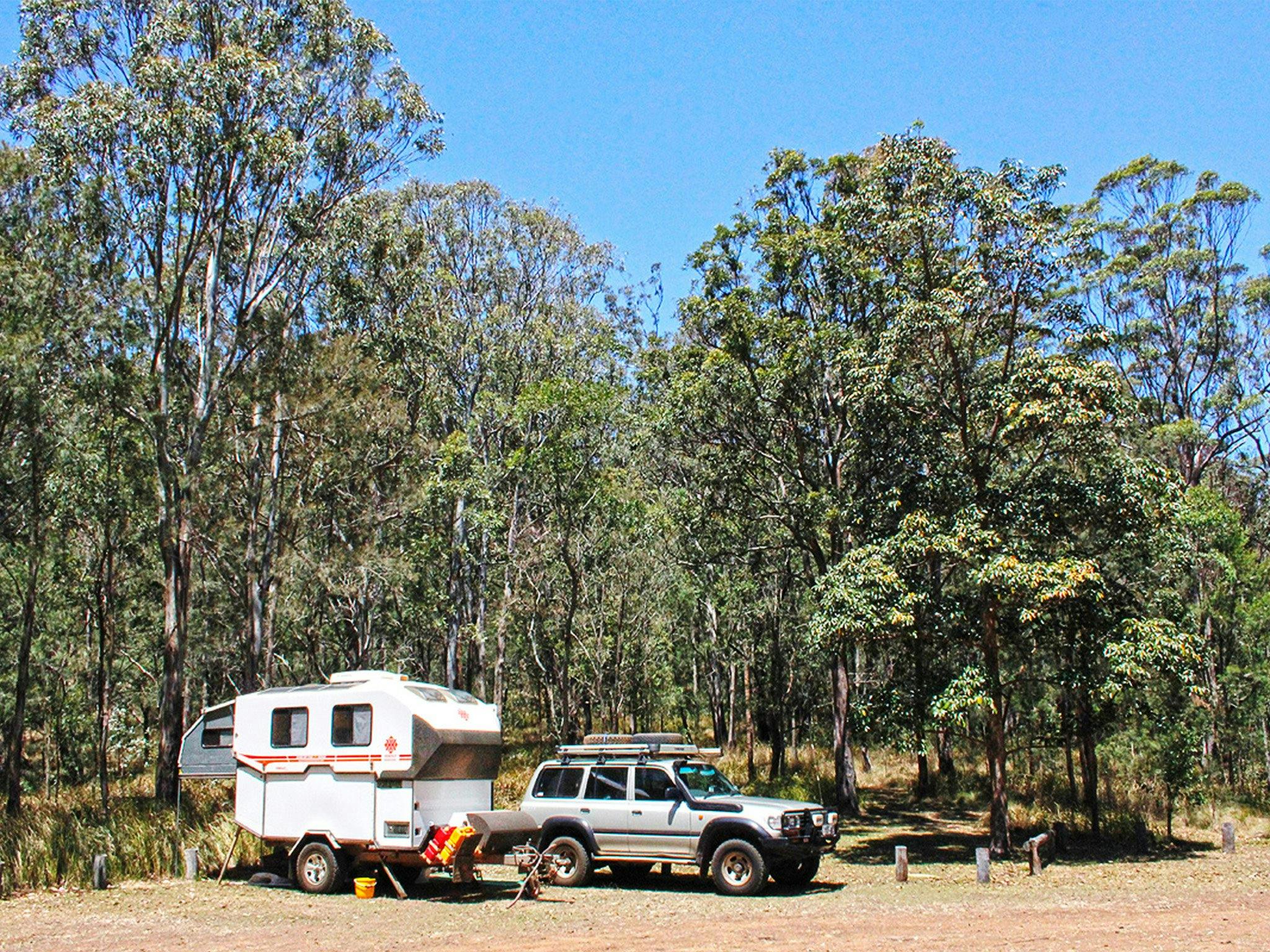 4WD and caravan set up near forest. 4WD and caravan set up near forest.