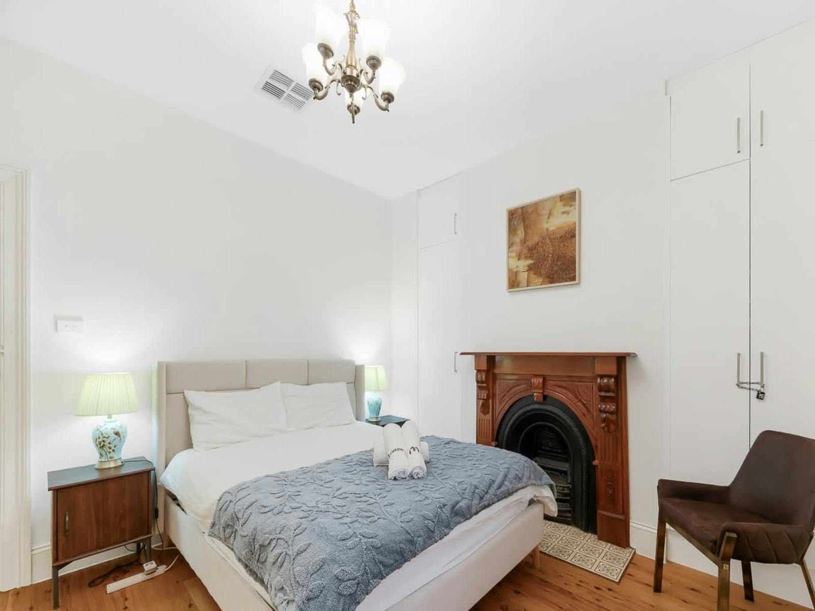 Spacious bedroom with decorative fireplace and bedside tables