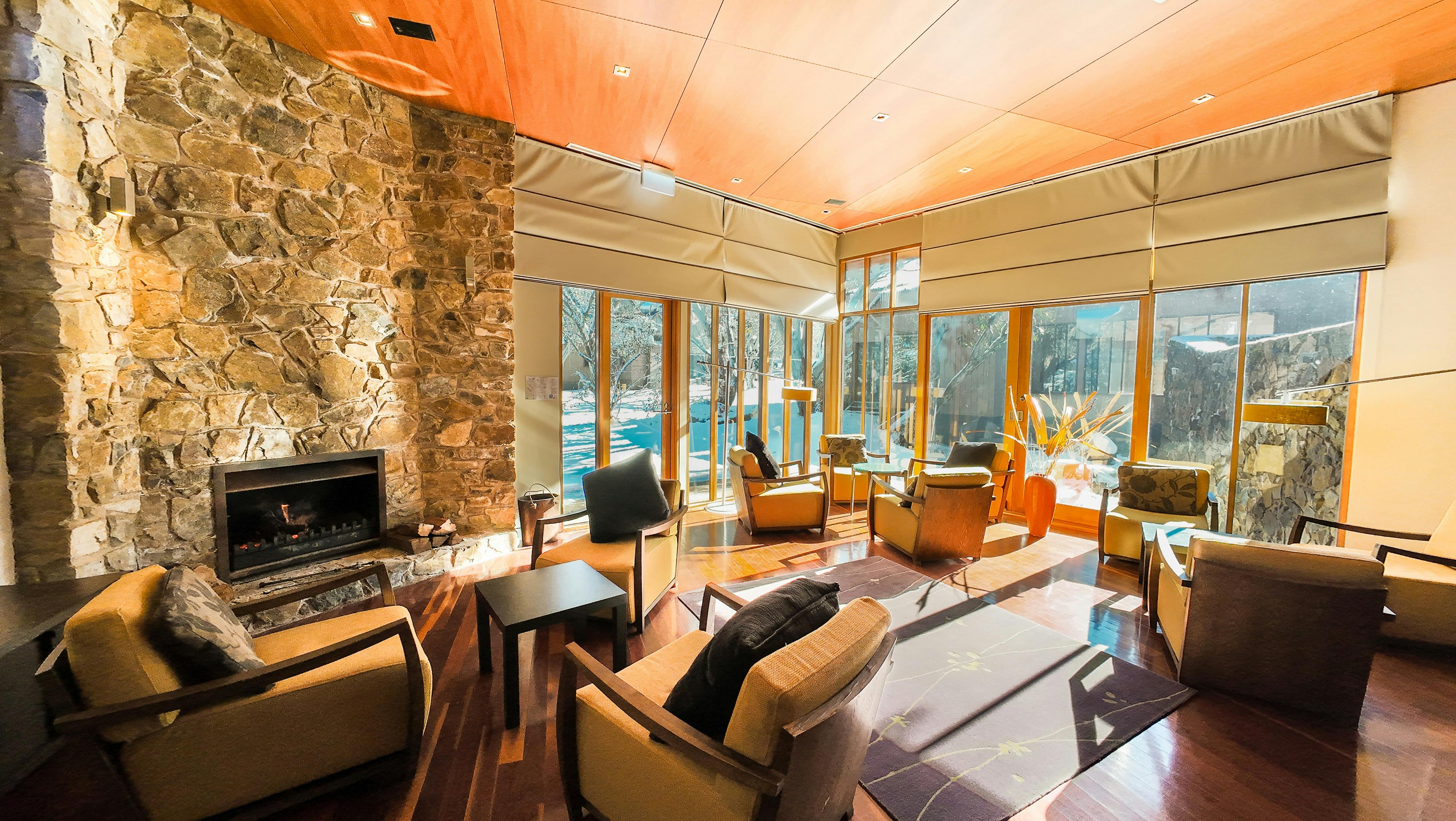 Lounge room with chairs and a stone wall with a fireplace