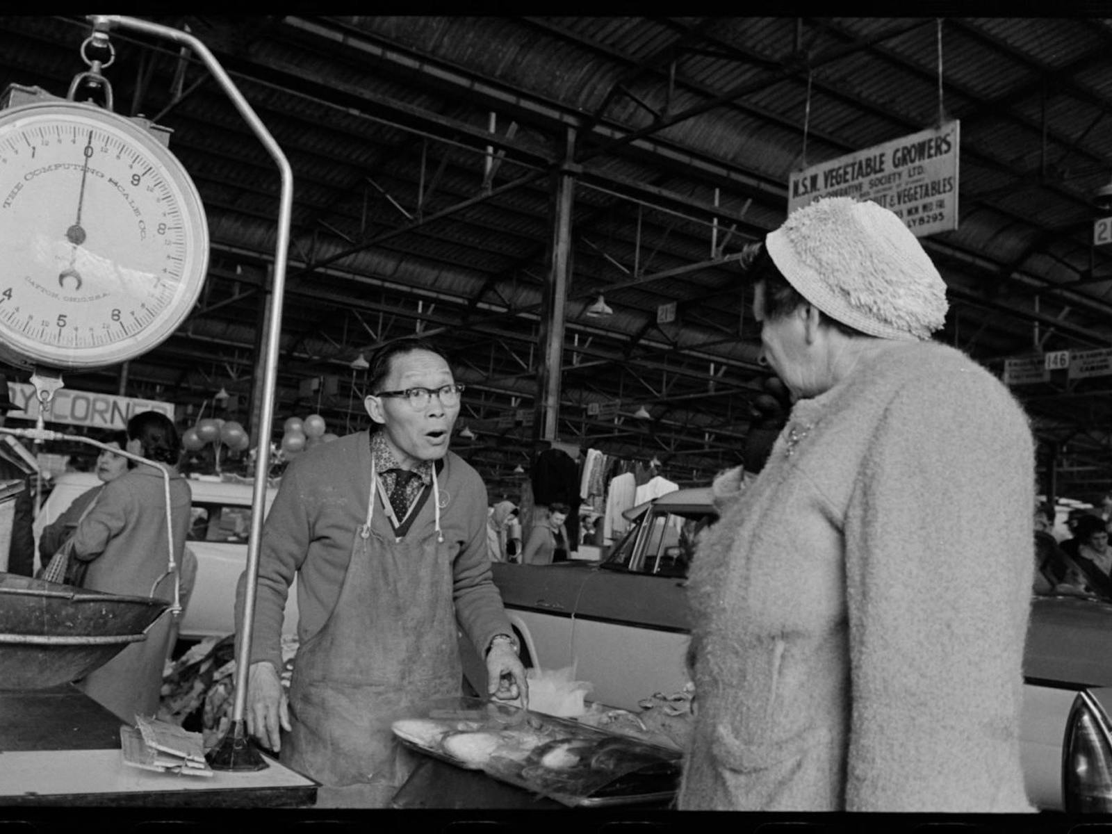 Black and white photograph of a fishmonger at a market