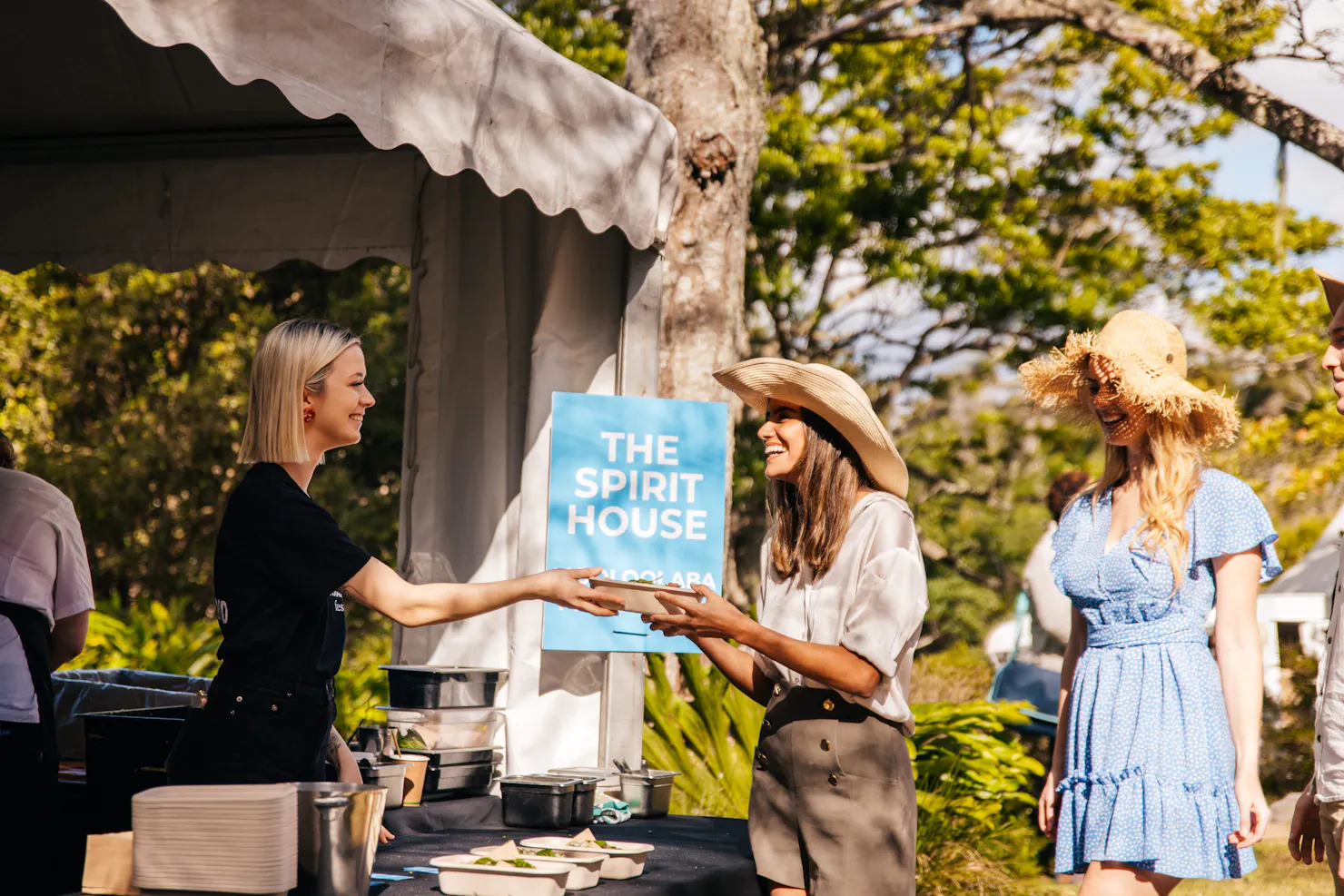 Two women at the festival getting food from a Spirit House food stall