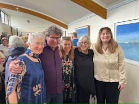 Lady in blue, man purple shirt, lady black floral, lady black floral, lady white top red lipstick.
