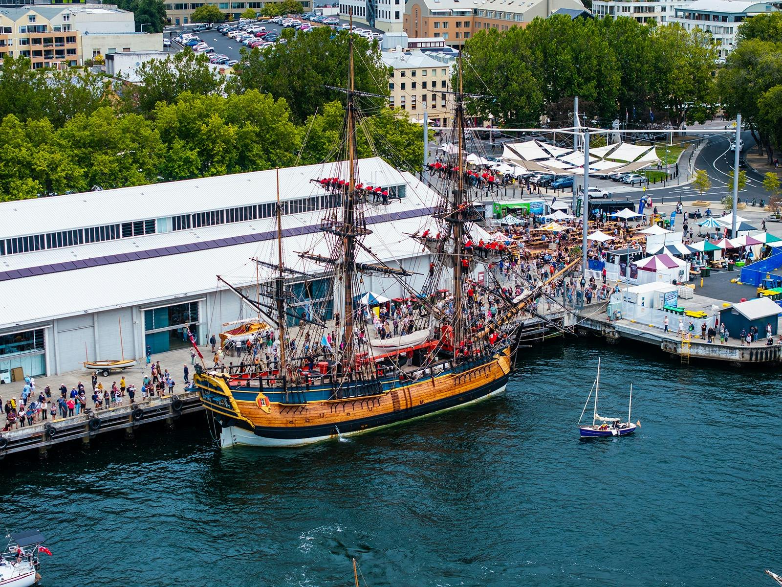 Crowds board a tall ship